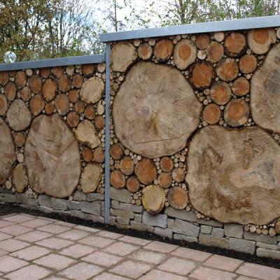 Der Sichtschutz aus Holzscheiben ist eine Alternative zum Gabionenzaun