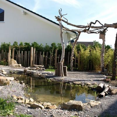 Kleiner Teich mit Sitzplatz aus Kies und Pergola aus Robinienholz