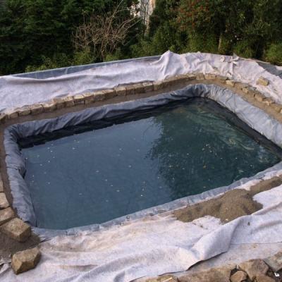 Nachdem der Schwimmbereich zum Teil mit Wasser befühlt ist, wird die Trennmauer gesetzt.